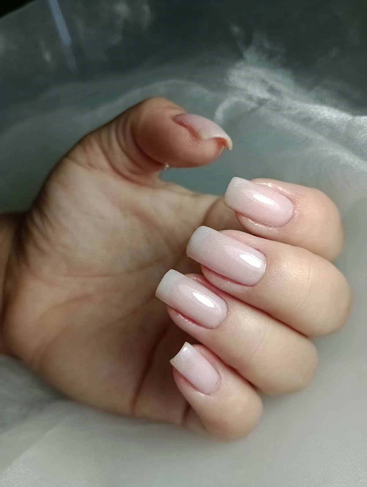 Unhas quadradas em rosa claro com brilho sutil